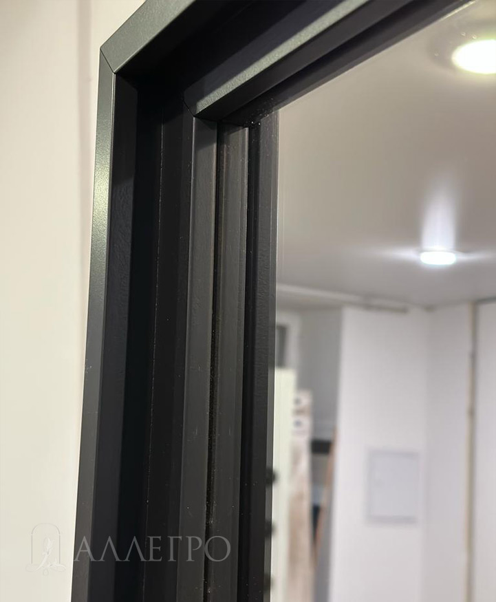 Багет выполнен в минималистском стиле. Имеет простые формы. Выкрашен в стильный черный цвет, как и сам профиль двери и скрытой коробки.